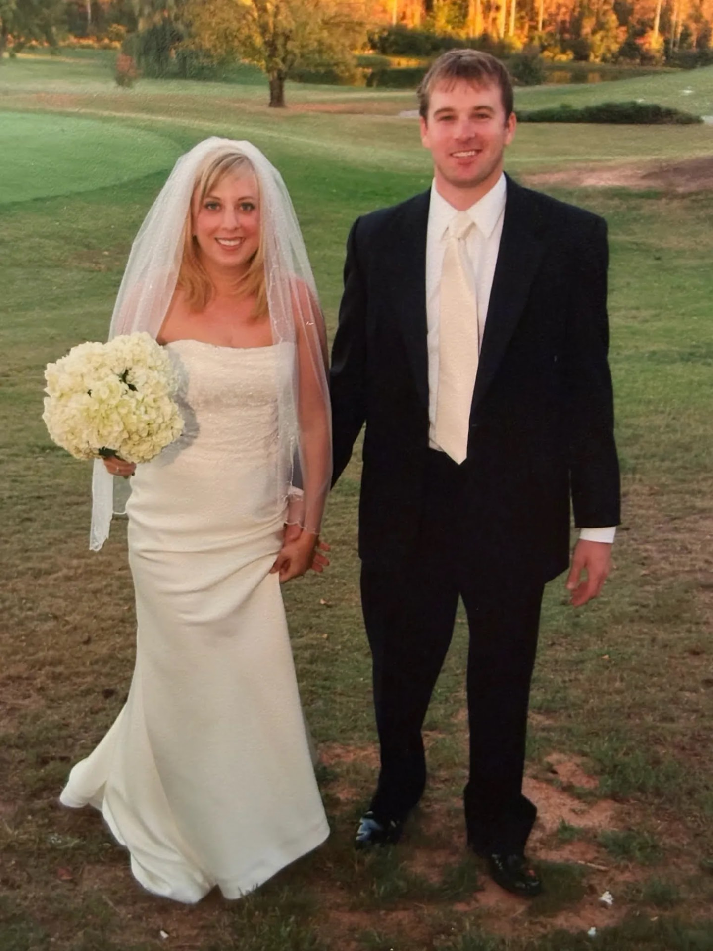 Emily and Ward holding hands on a golf course on their wedding day